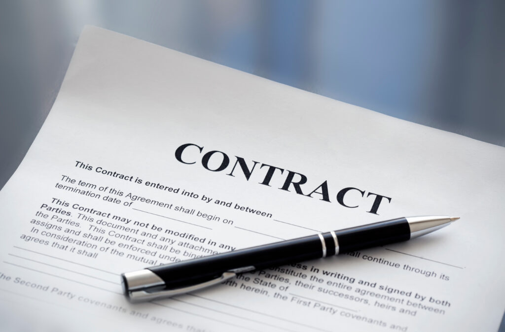 An image of a referral agreement contract with a pen sitting on top of it.